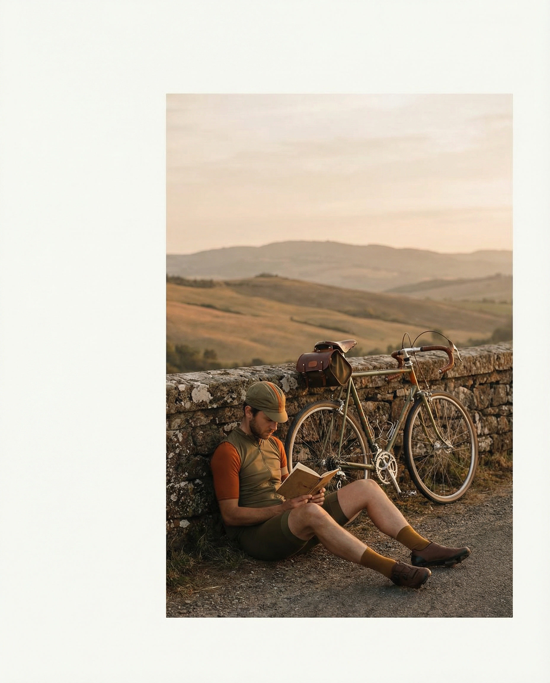 gemini-image-2_Solo_cyclist_resting_beside_a_road_with_rolling_hills_and_golden_light_in_the_di-0